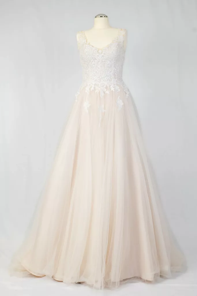 Elegantes Secondhand-Brautkleid mit Spitzenoberteil und weitem Tüllrock in Elfenbein auf Mannequin präsentiert