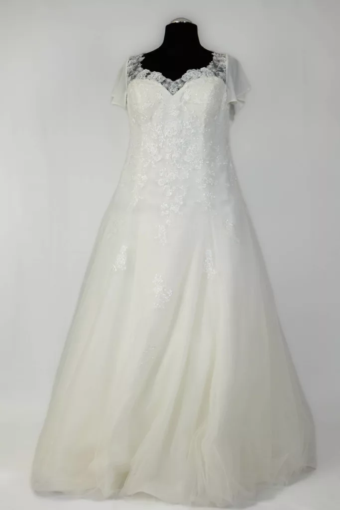 Hochzeitskleid mit Spitzenapplikationen und kurzen Ärmeln auf Mannequin, angeboten von Brautboutique Aktuell in Weißenburg, perfekt für eine Vintage-Hochzeit.